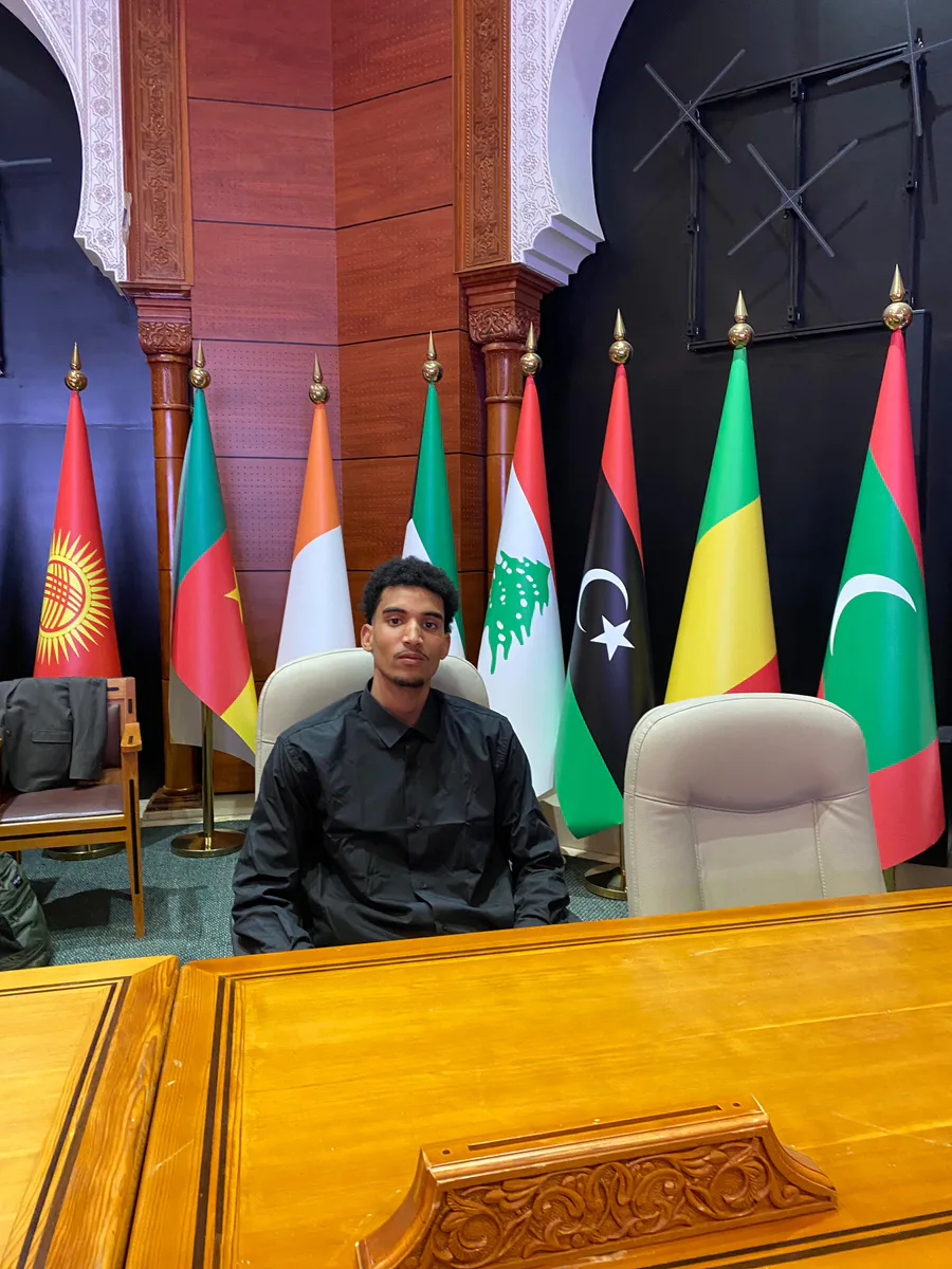 Abdelwahed seated at an international conference table